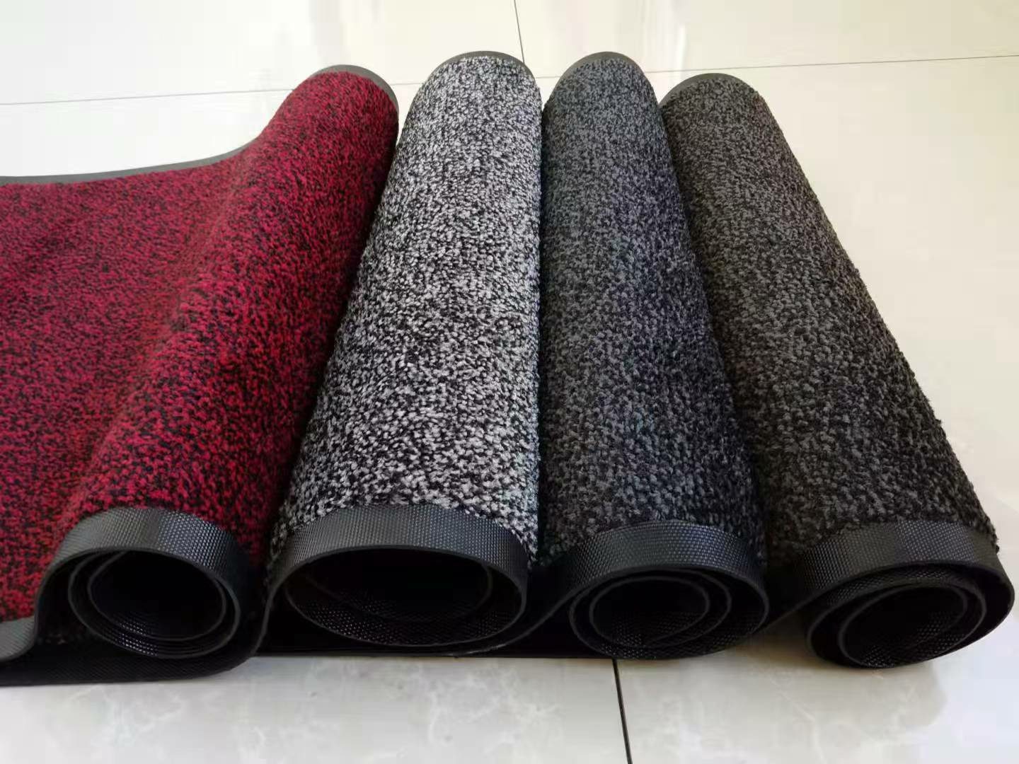 Rolled entrance mats in red, grey and charcoal